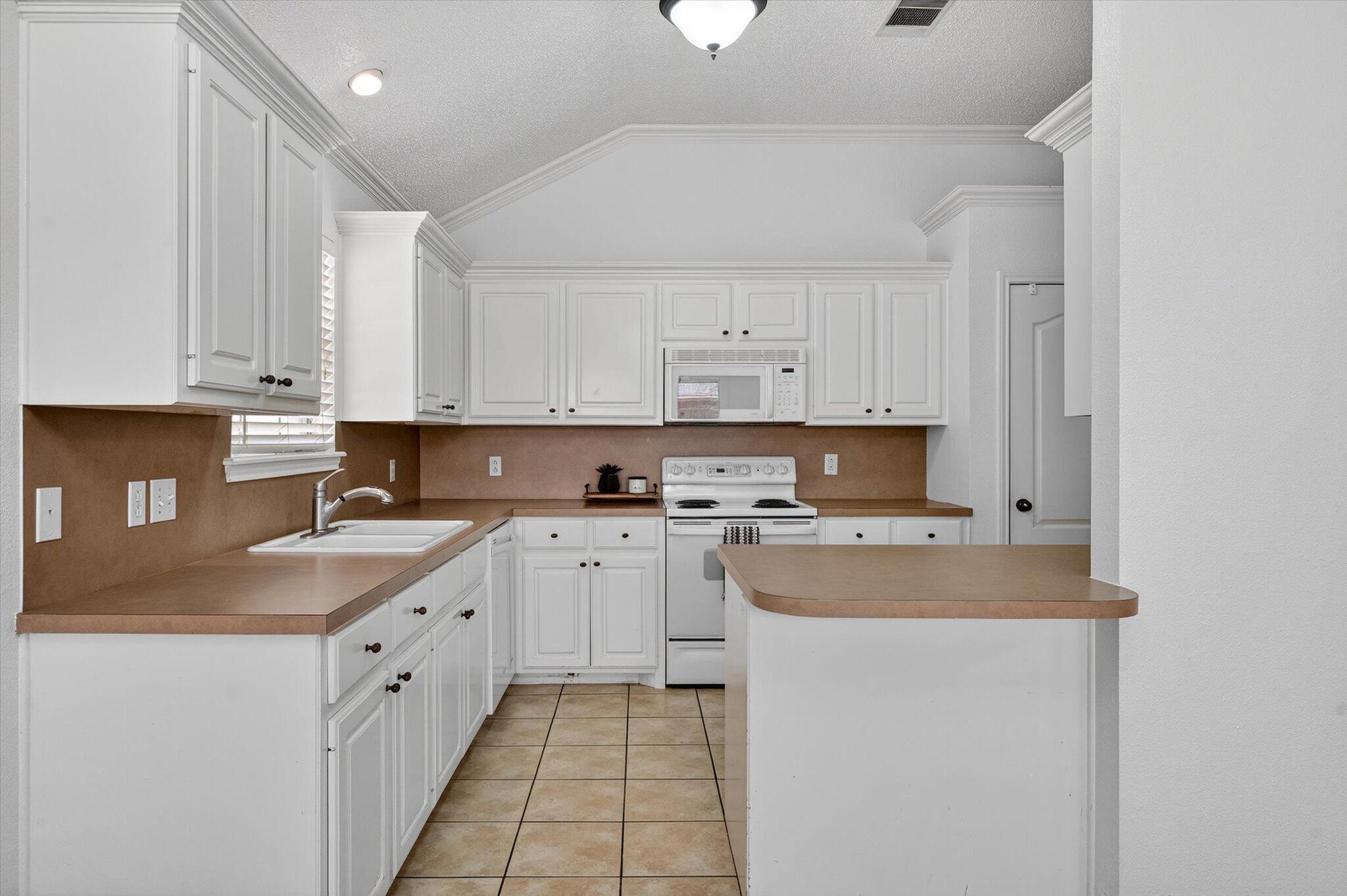 2216 97th Street Lubbock, TX 79423 - Photo 12 of 29 a kitchen with stainless steel appliances granite countertop a sink and dishwasher a stove top oven with white cabinets
