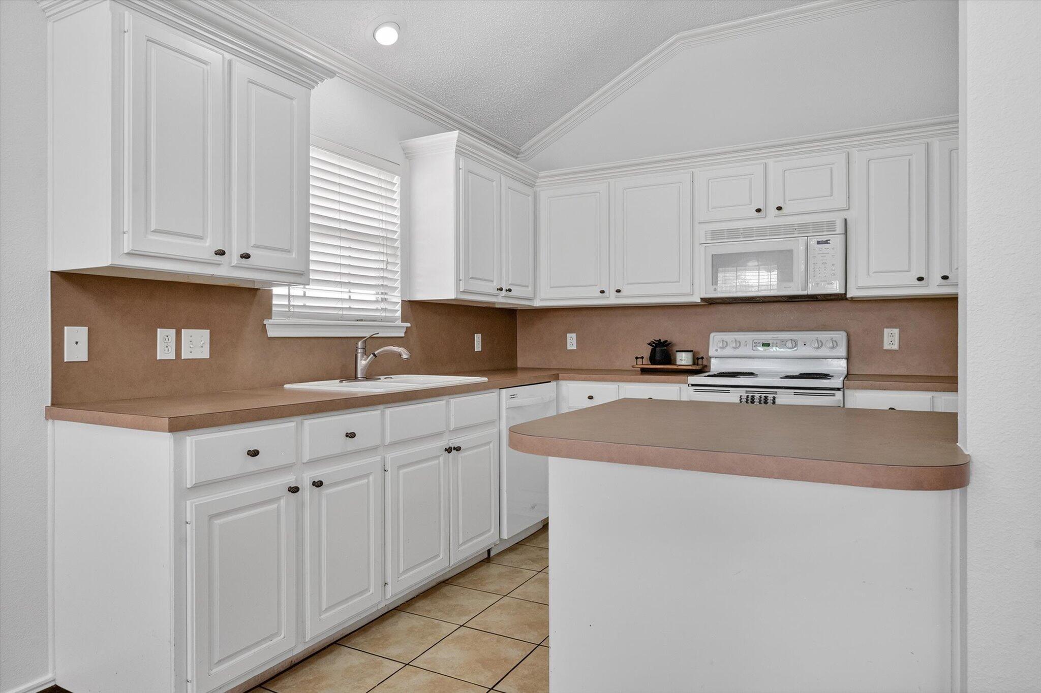 2216 97th Street Lubbock, TX 79423 - Photo 13 of 29 a kitchen with stainless steel appliances granite countertop a sink a stove and white cabinets