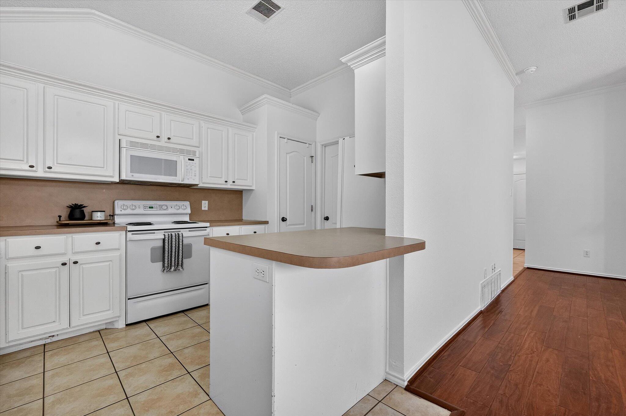 2216 97th Street Lubbock, TX 79423 - Photo 14 of 29 a kitchen with granite countertop white cabinets and white appliances