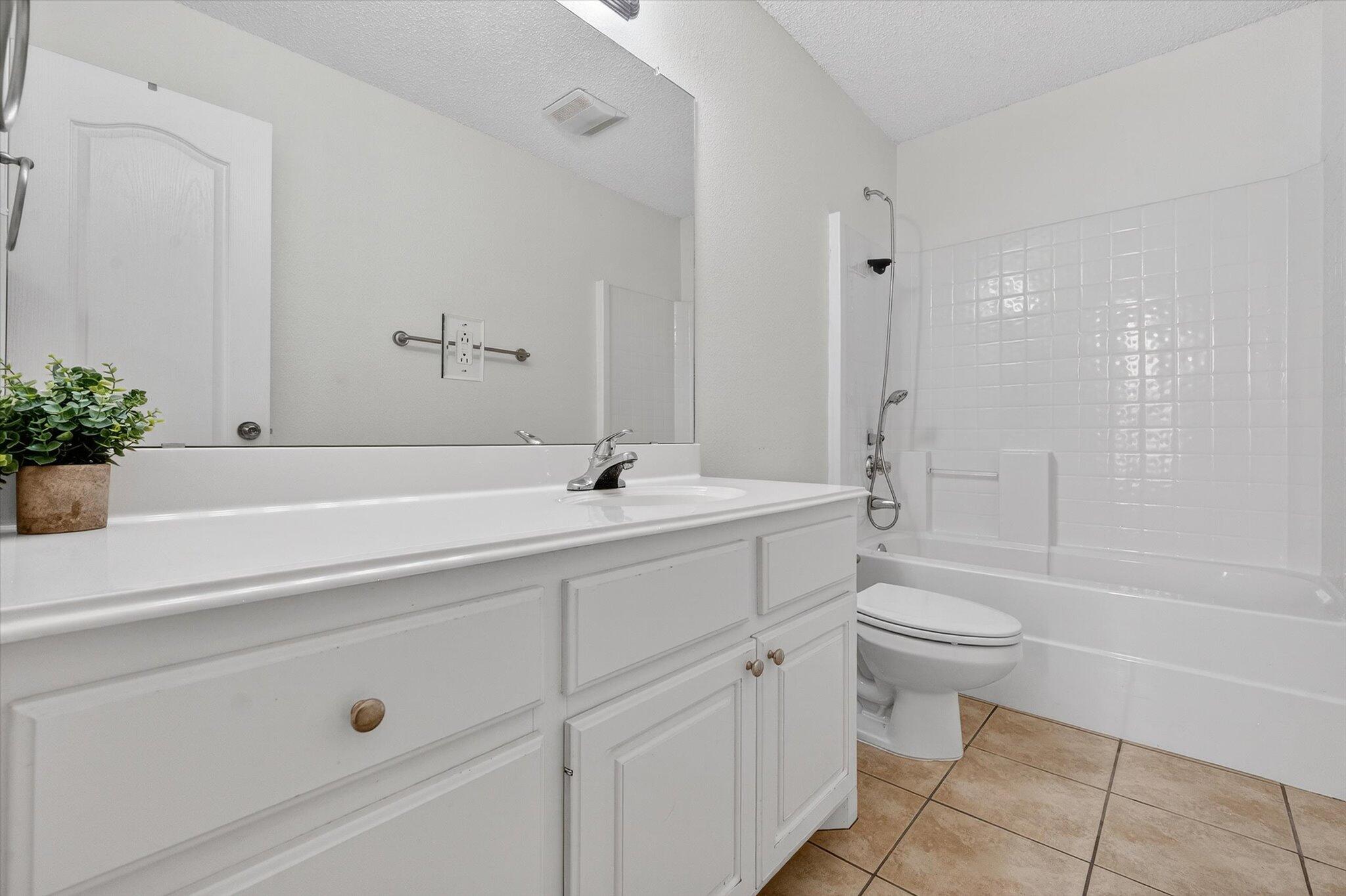 2216 97th Street Lubbock, TX 79423 - Photo 19 of 29 a bathroom with a sink a toilet and shower
