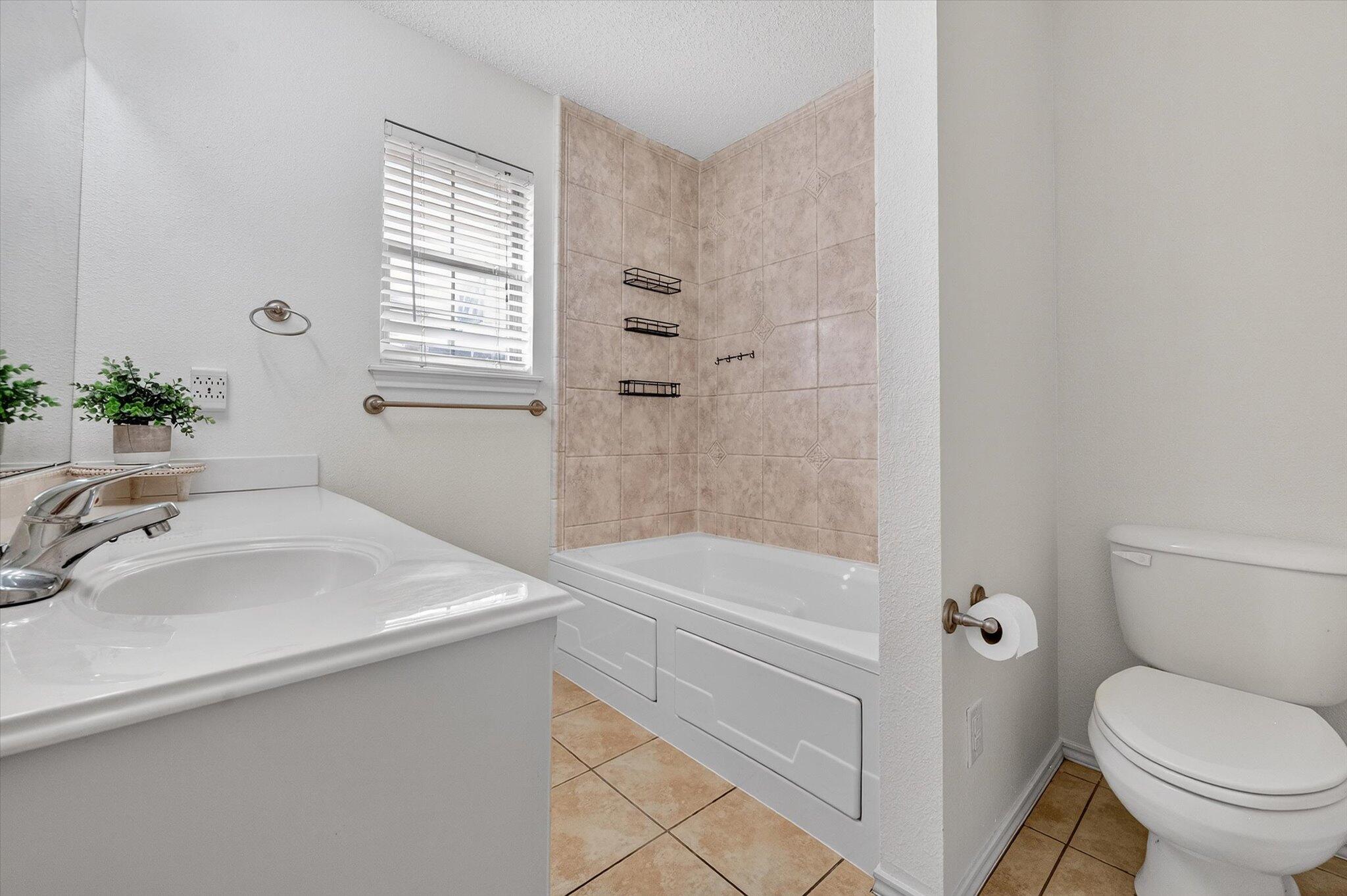 2216 97th Street Lubbock, TX 79423 - Photo 24 of 29 a bathroom with a sink a toilet and a bathtub