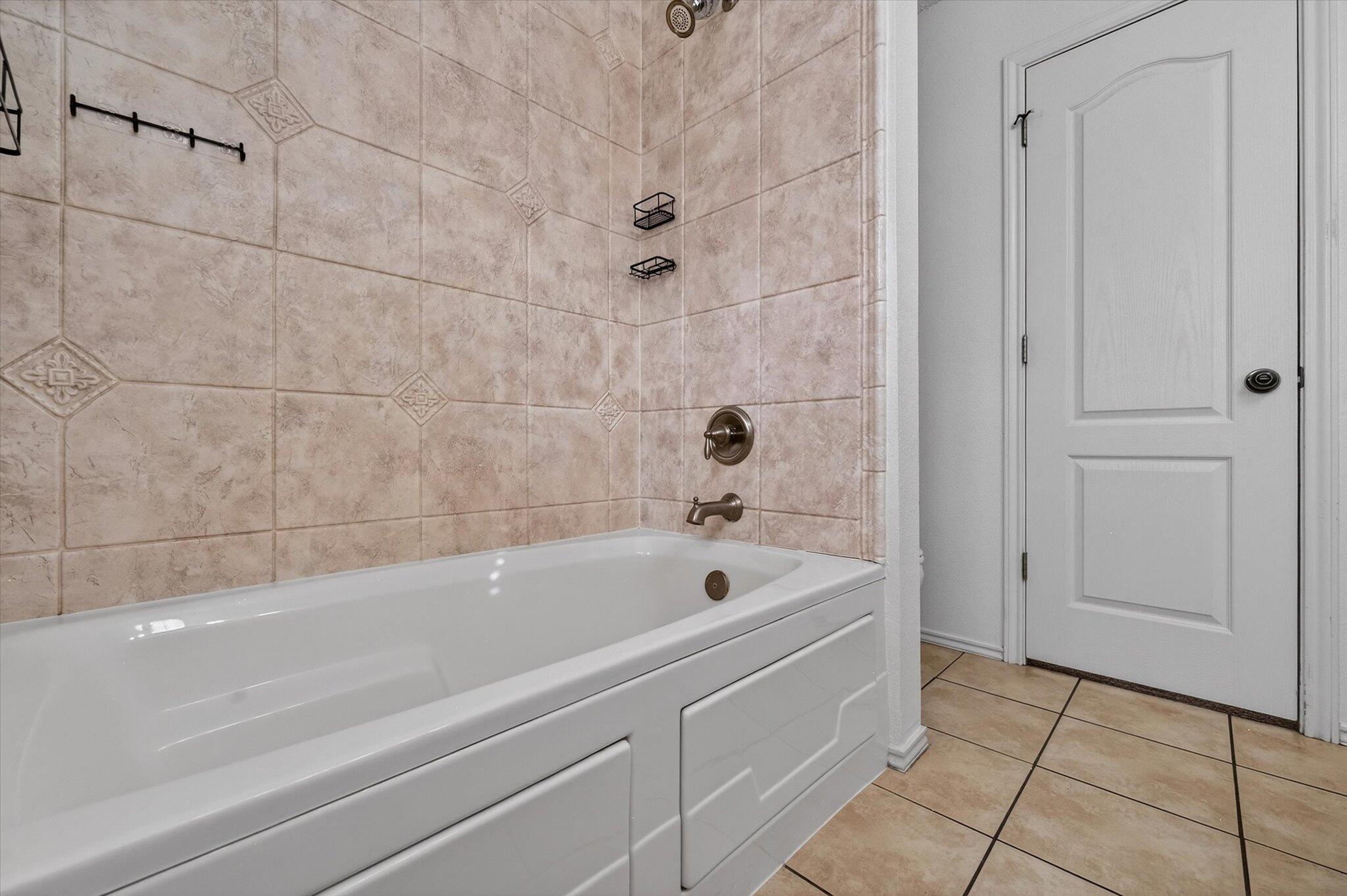 2216 97th Street Lubbock, TX 79423 - Photo 25 of 29 a bathroom with a bathtub and shower