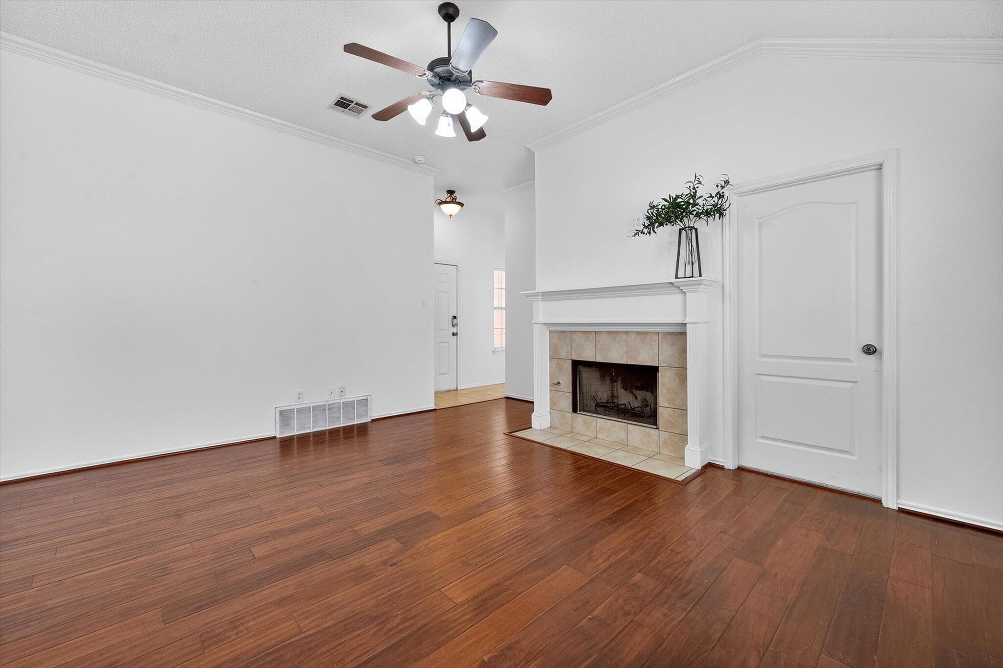 2216 97th Street Lubbock, TX 79423 - Photo 7 of 29 a view of an empty room with wooden floor fireplace and a window