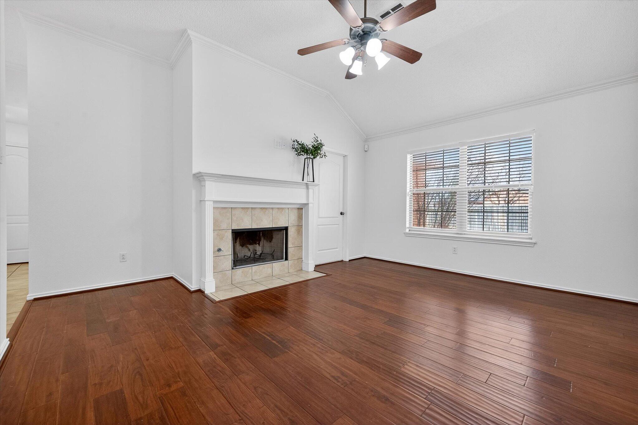 2216 97th Street Lubbock, TX 79423 - Photo 8 of 29 an empty room with windows chandelier fan and fireplace