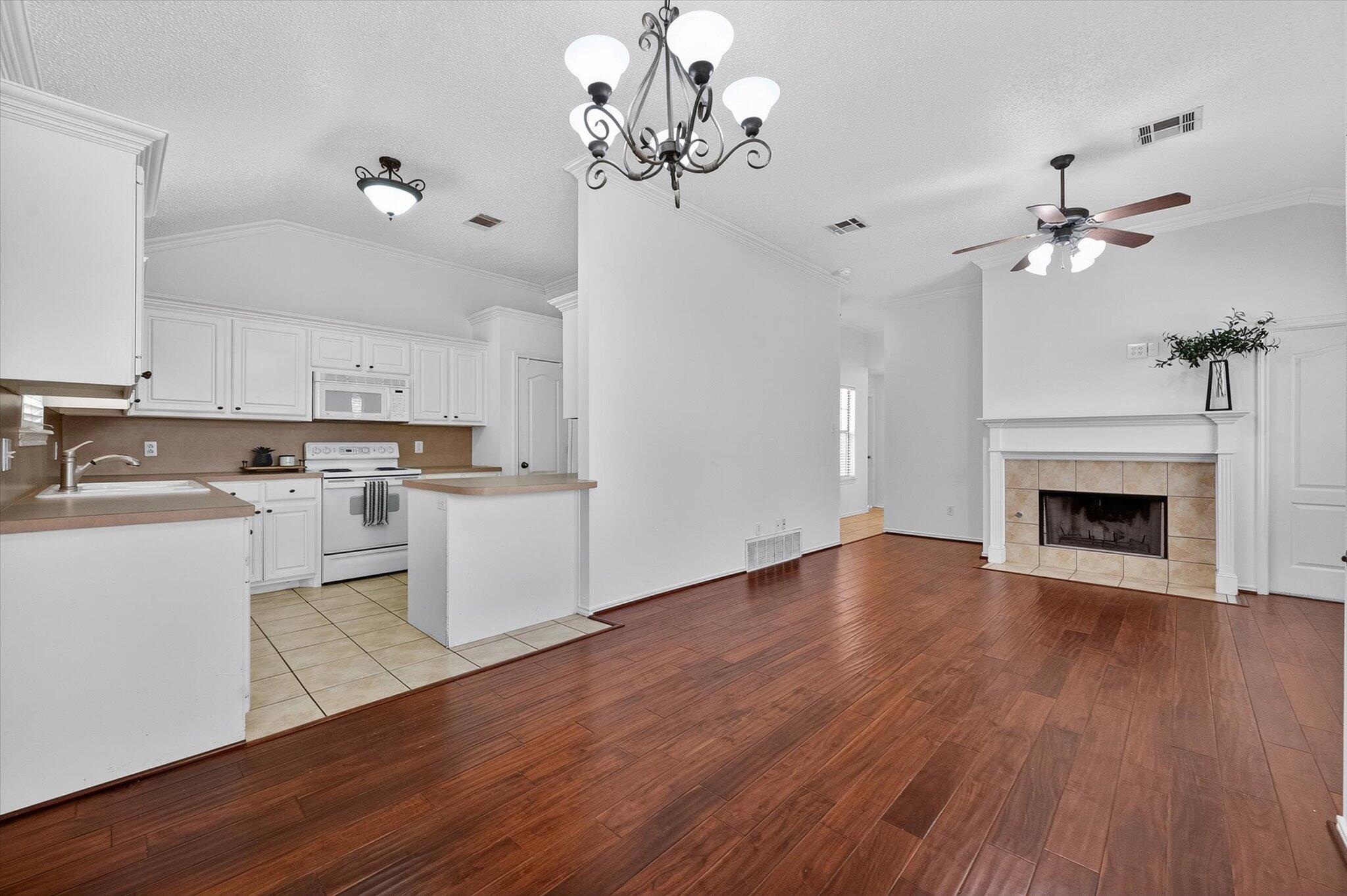 2216 97th Street Lubbock, TX 79423 - Photo 10 of 29 a view of a kitchen with a dishwasher a kitchen microwave and wooden floor