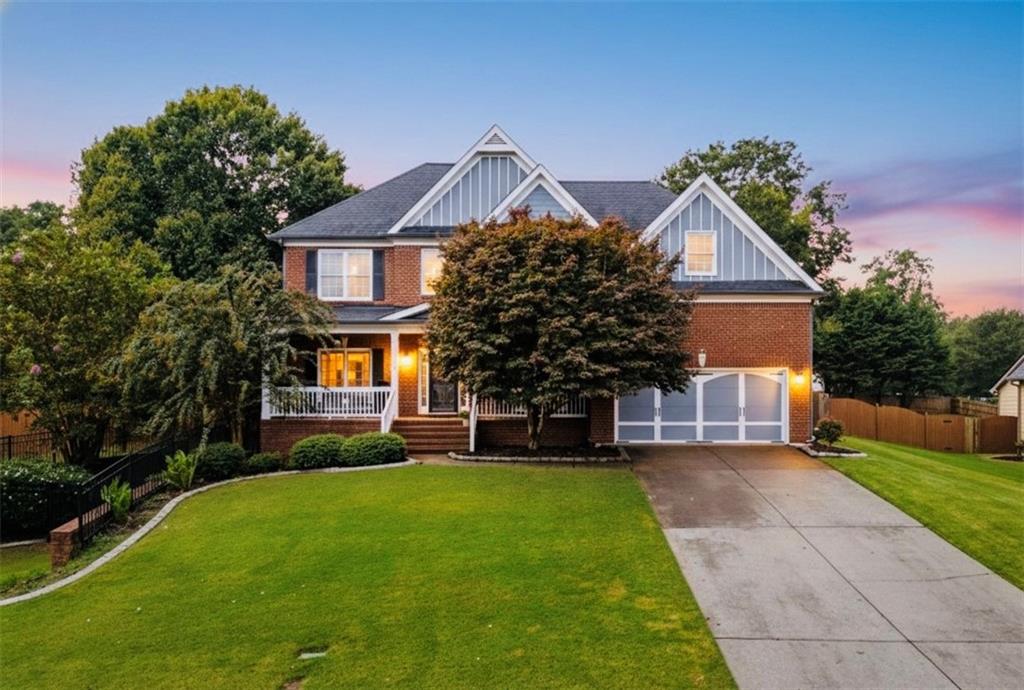 a front view of a house with a yard and trees