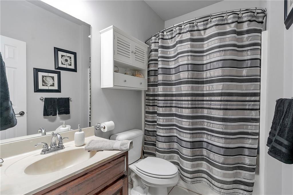 1224 Treemont Trace Winder, GA 30680 - Photo 19 of 27 a bathroom with a sink a toilet and shower curtain
