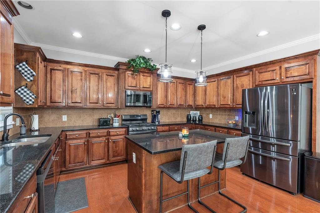 1224 Treemont Trace Winder, GA 30680 - Photo 2 of 27 a kitchen with stainless steel appliances granite countertop a stove a sink refrigerator and cabinets