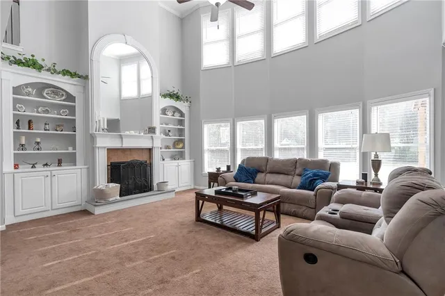 a living room with furniture fireplace and a large window