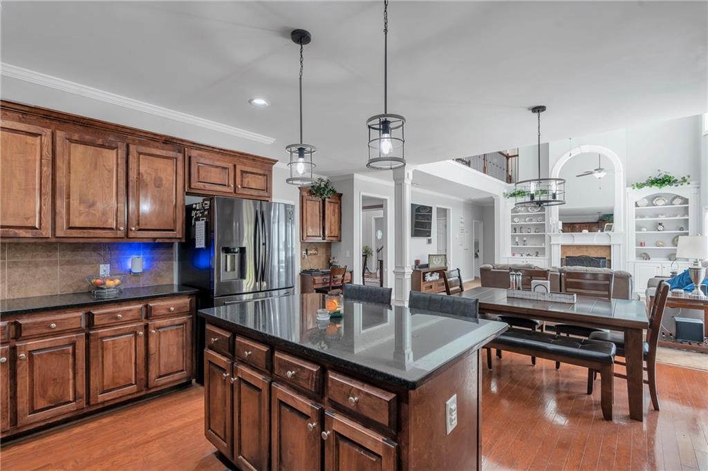 1224 Treemont Trace Winder, GA 30680 - Photo 8 of 27 a kitchen with stainless steel appliances granite countertop a stove a sink dishwasher a dining table and chairs with wooden floor