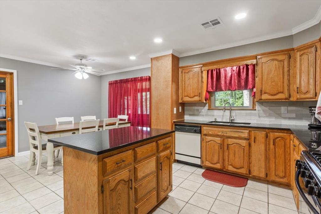 109 Hilltop Street Riesel, TX 76682 - Photo 12 of 32 a kitchen with stainless steel appliances granite countertop a stove a sink and a microwave