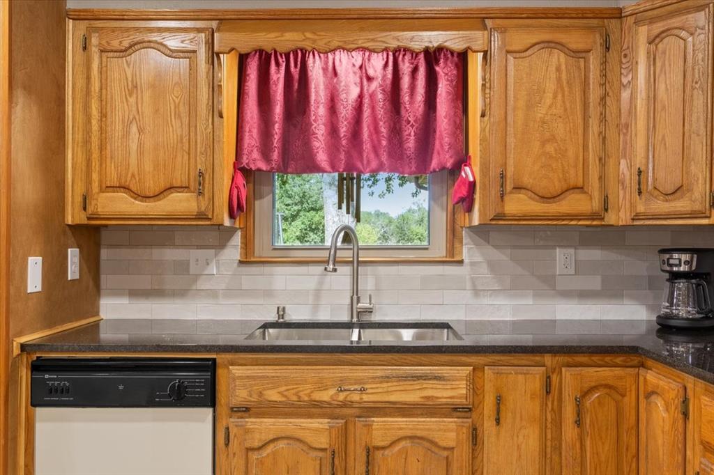 109 Hilltop Street Riesel, TX 76682 - Photo 13 of 32 a kitchen with stainless steel appliances granite countertop a sink a window and red cabinets