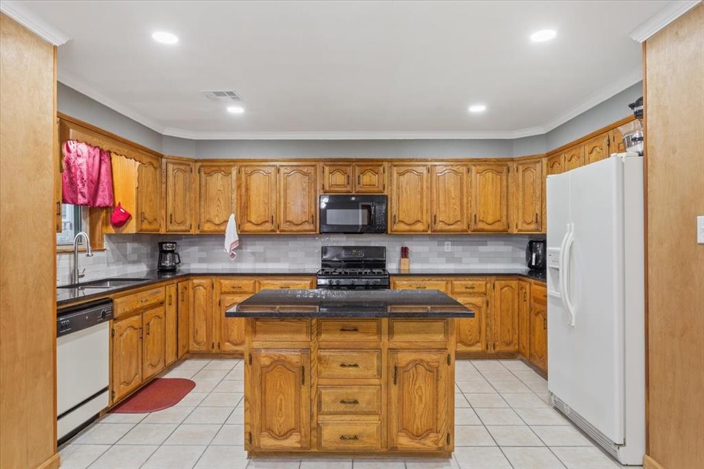 109 Hilltop Street Riesel, TX 76682 - Photo 14 of 32 a kitchen with stainless steel appliances granite countertop a stove a sink and a refrigerator