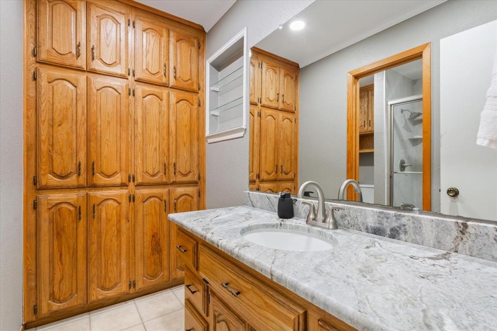 109 Hilltop Street Riesel, TX 76682 - Photo 23 of 32 a bathroom with a granite countertop sink and a mirror