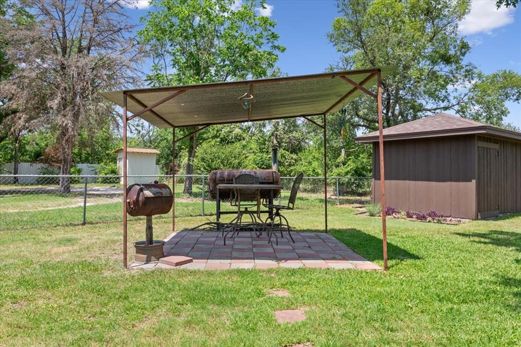 109 Hilltop Street Riesel, TX 76682 - Photo 30 of 32 a view of backyard with table and chairs under an umbrella