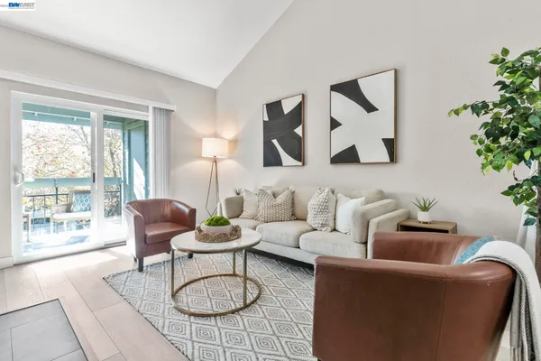 a living room with furniture a rug and a large window