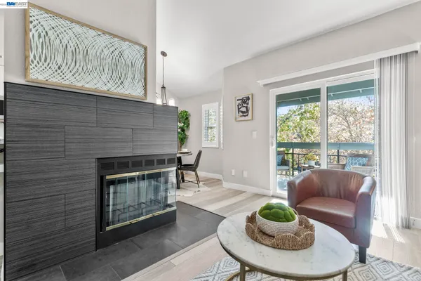 a living room with furniture a fireplace and a large window