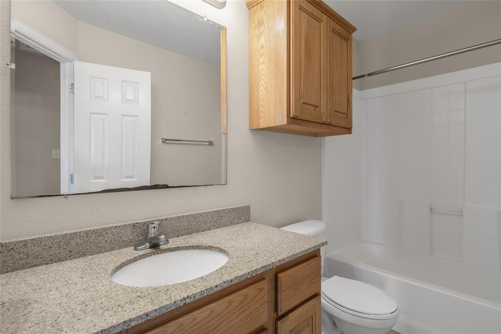 1001 Krenek Tap Road, Unit 801 College Station, TX 77840 - Photo 14 of 21 a bathroom with a granite countertop sink toilet and mirror