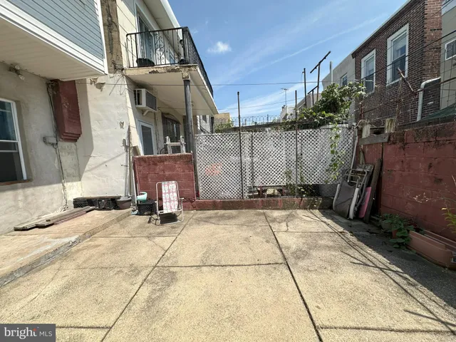 a view of a patio with a table and chairs and wooden fence