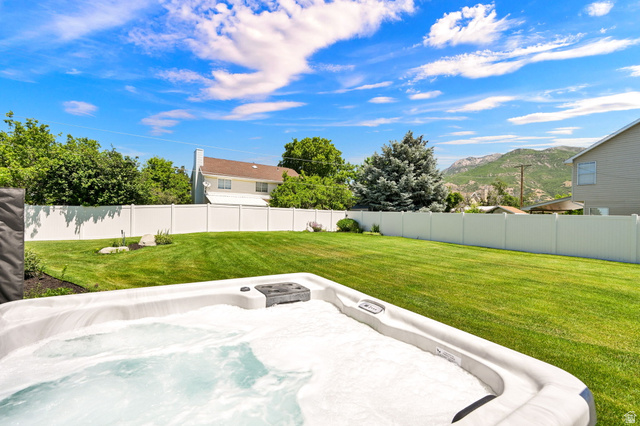 4792 Glasmann Way South Ogden, UT 84403 - Photo 26 of 70 Spacious backyard featuring a hot tub, manicured lawn, and white privacy fencing