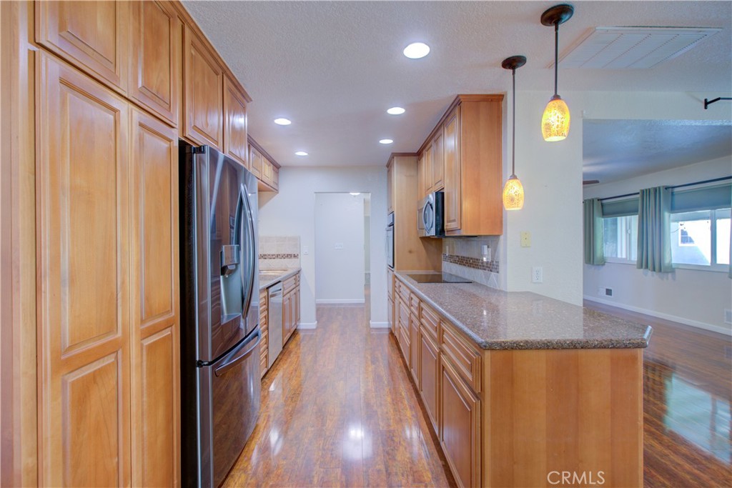 3728 Fuchsia Lane Modesto, CA 95356 - Photo 16 of 47 a kitchen with stainless steel appliances granite countertop a refrigerator a oven and a wooden cabinets
