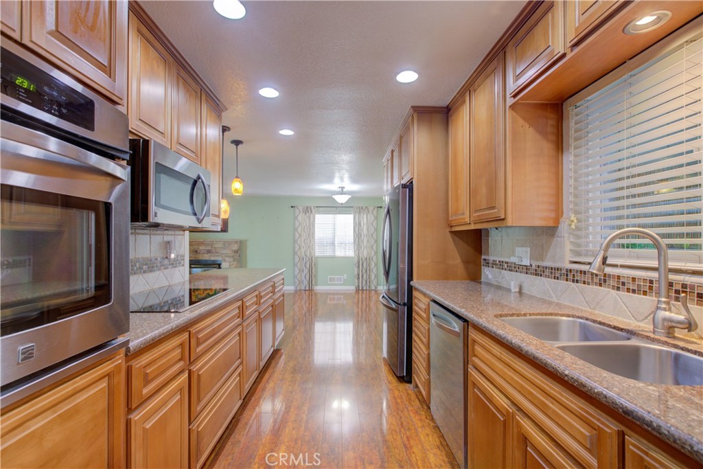 3728 Fuchsia Lane Modesto, CA 95356 - Photo 17 of 47 a kitchen with stainless steel appliances granite countertop a sink a stove and a wooden cabinets