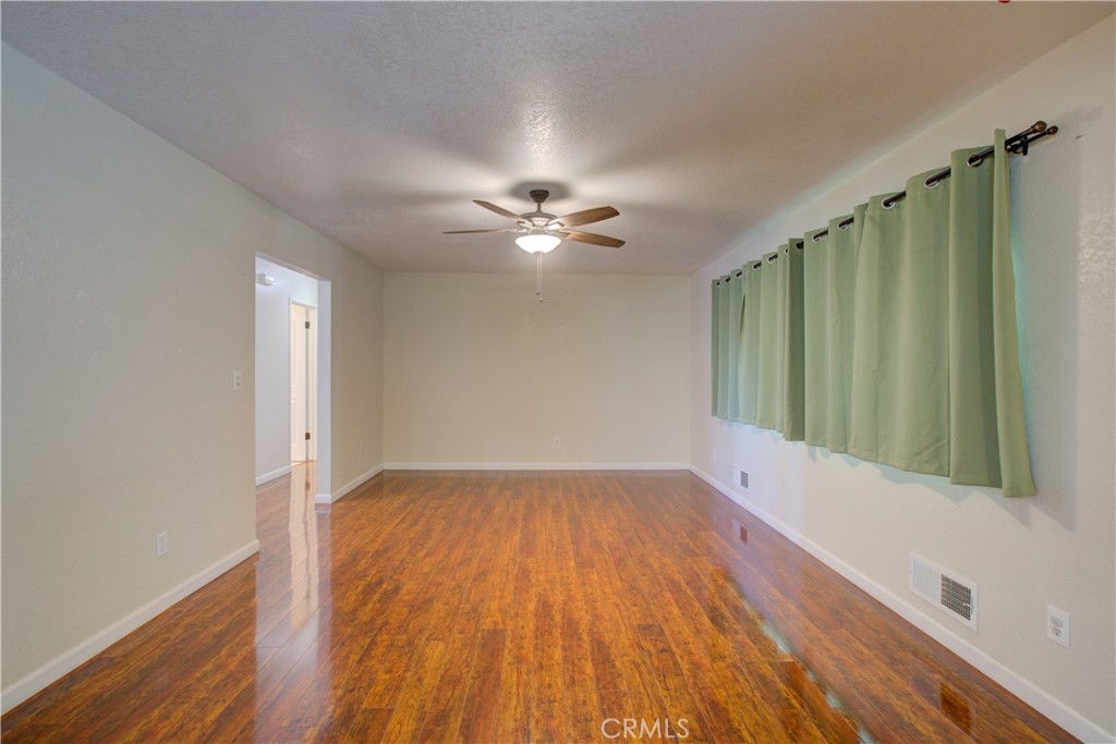 3728 Fuchsia Lane Modesto, CA 95356 - Photo 5 of 47 an empty room with wooden floor fan and windows