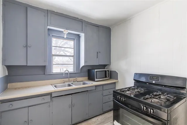 a kitchen with stainless steel appliances a sink a stove and a window