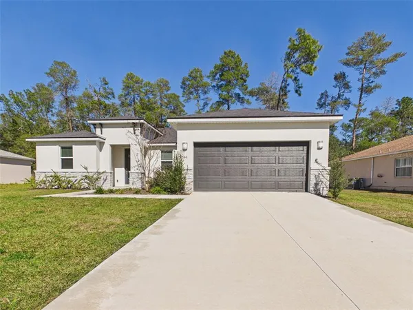 a front view of a house with a yard and garage