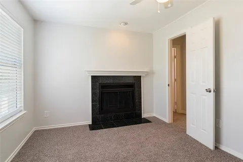 an empty room with a fireplace and window