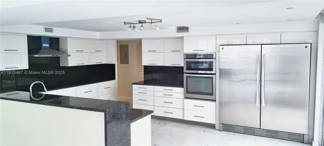 a kitchen with appliances a sink and cabinets