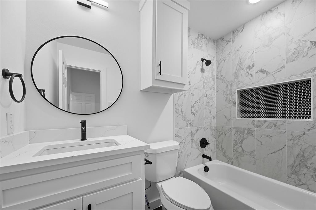 1315 Oneal Street, Unit B Commerce, TX 75428 - Photo 13 of 17 a bathroom with a sink a toilet and a mirror