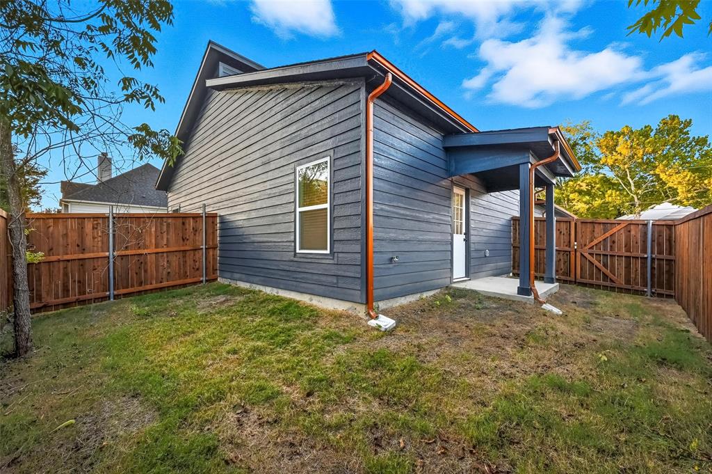1315 Oneal Street, Unit B Commerce, TX 75428 - Photo 16 of 17 a view of backyard with wooden fence and a large tree