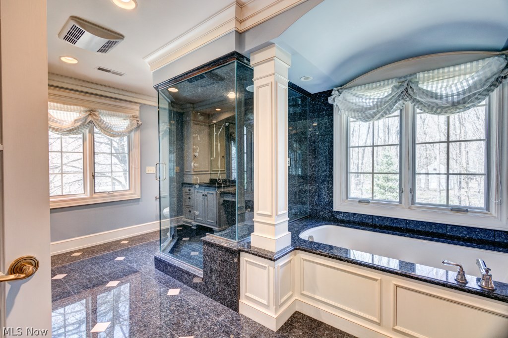 1739 Chartley Road Gates Mills, OH 44040 - Photo 18 of 25 Here is the updated spa-like Master Bath! A soaking tub is flanked by stately white columns, has an arched ceiling, and a blue pearl granite top that continues around the window and side wall. The front of the tub is covered in white wainscoting. Imagine relaxing in here after a long day! There's also a wide steam shower swathed in blue pearl granite and featuring multiple heads