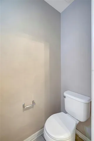 a white toilet sitting next to a white wall