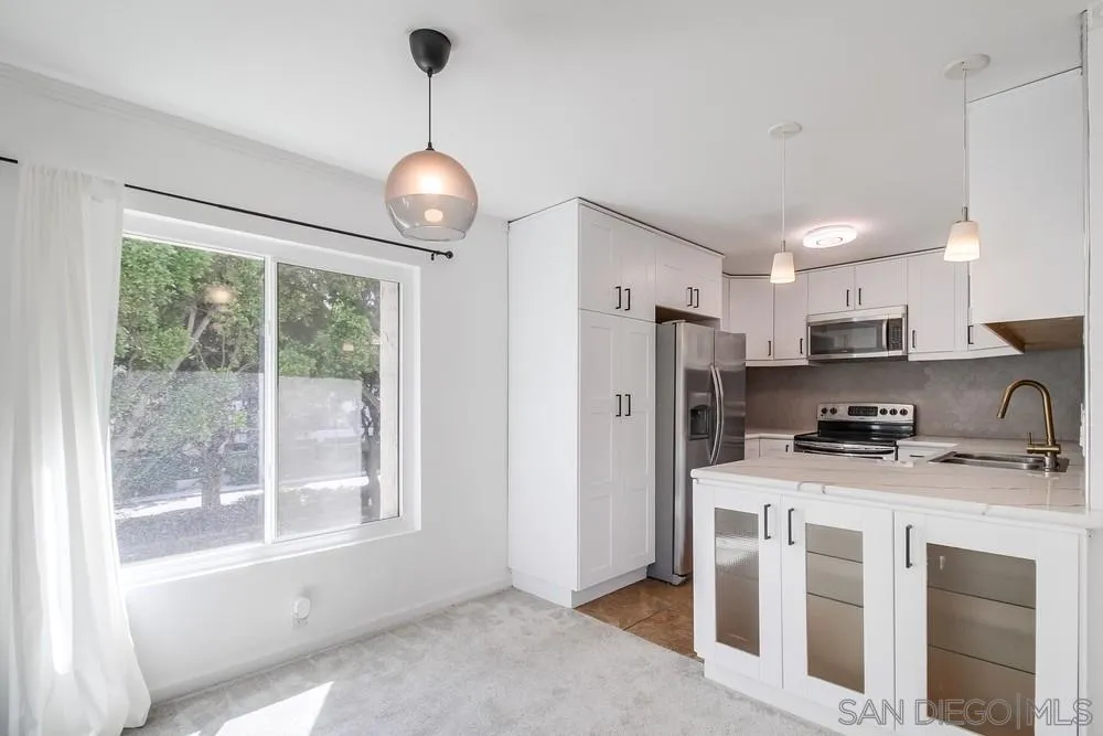 5645 Friars Road, Unit 363 San Diego, CA 92110 - Photo 11 of 74 a kitchen with stainless steel appliances granite countertop a stove a refrigerator a oven with white cabinets and couches