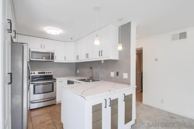 a kitchen with granite countertop white cabinets and a sink