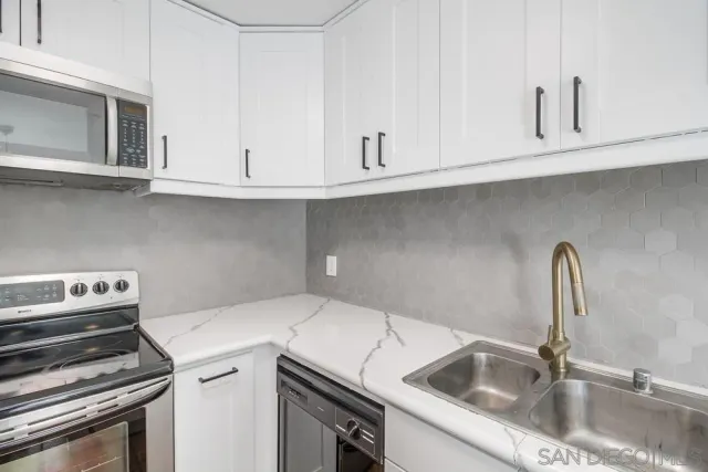 a view of an empty room with closet and a window