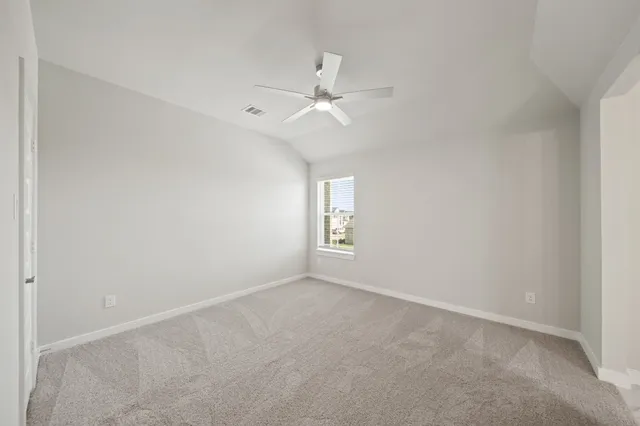 an empty room with a window and ceiling fan