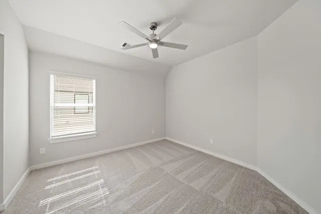 an empty room with a window and a ceiling fan