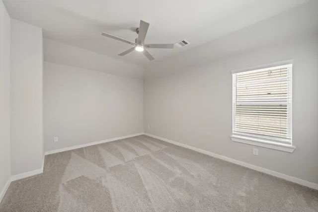 an empty room with a window and a fan