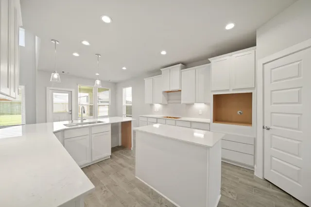 a large kitchen with kitchen island a sink stainless steel appliances and cabinets