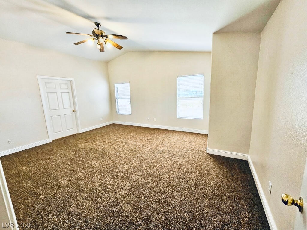 5953 Crumbling Ridge Street Henderson, NV 89011 - Photo 16 of 42 A spacious bedroom boasts high vaulted ceilings, plush carpeting, and abundant natural light.