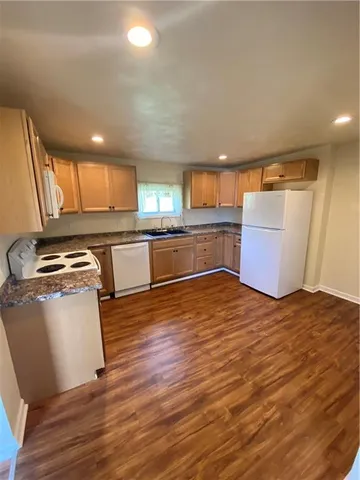 a kitchen with stainless steel appliances granite countertop a sink and wooden cabinets