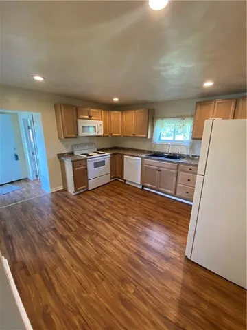 a kitchen with stainless steel appliances wooden floors and wooden cabinets