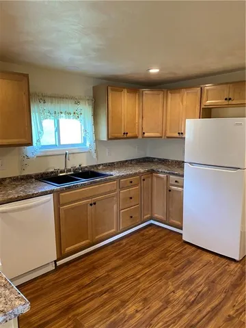 a kitchen with wooden floors and white appliances