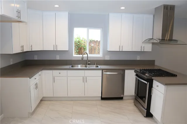 a kitchen with granite countertop white cabinets and white appliances