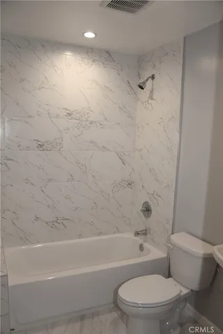 a bathroom with a toilet and a bath tub