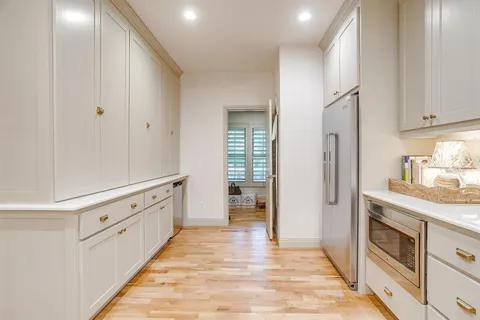 a kitchen with granite countertop white cabinets and white appliances