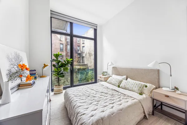 a bed sitting in a bedroom next to a window